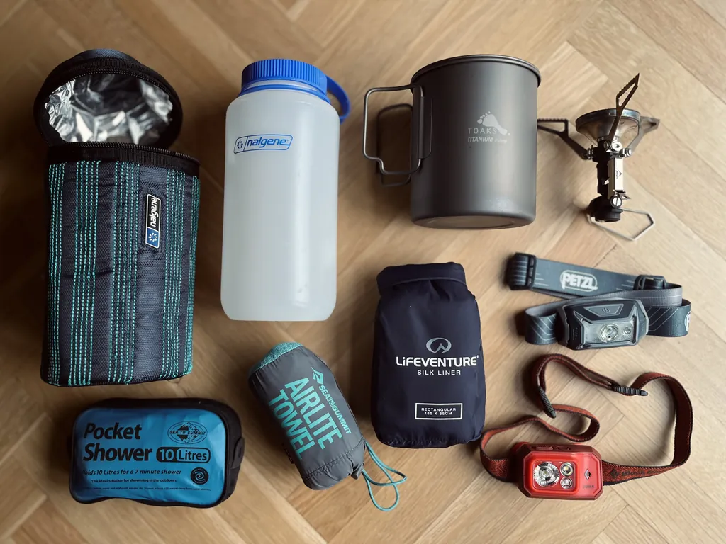 flat lay of small lightweight gear essentials for mountaineering on wooden floor